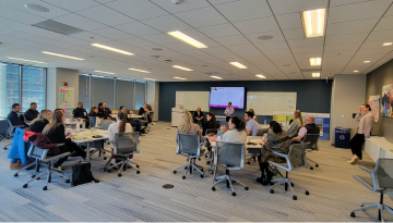 SCJ Chicago team participating in a group training; Groups seated at tables discussing topics