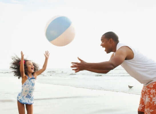 father and daughter playing on the beach