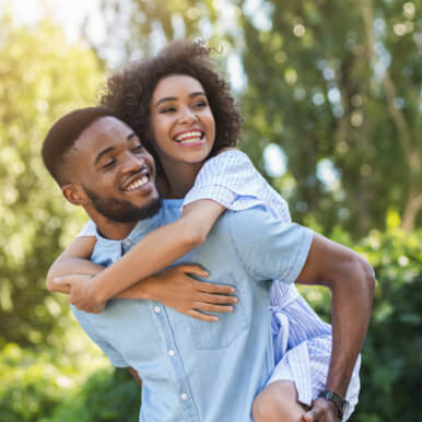 Man walking while carrying girl on his back