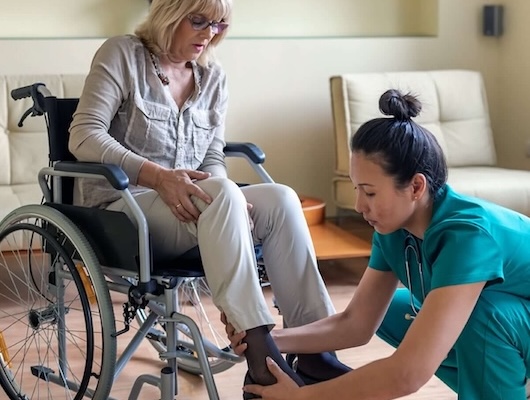 Home care nurse helping a woman at home in her wheelchair