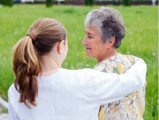 Nurse comforting woman in the park