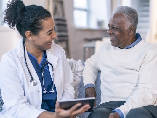 Clinician with member on couch with tablet