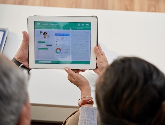 Two people reviewing health records on a tablet