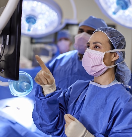 Surgeon in surgery room looking at screen