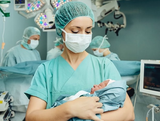 Infant in surgical nurse arms