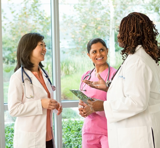 Three clinicians smiling at each other