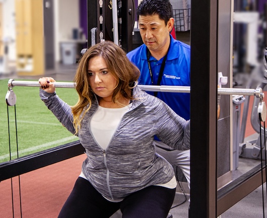 Physical Therapist helping woman exercise