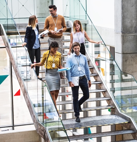 Coworkers talking as they descend stairs