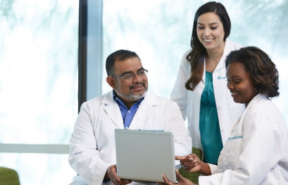 Three clinicians around an ipad