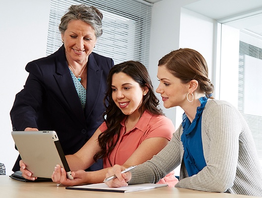 Three women working on a laptop