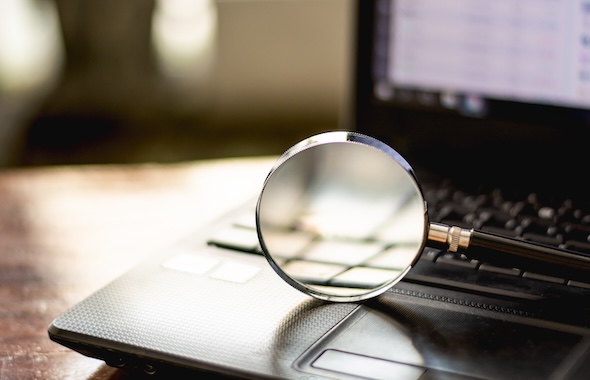 Magnifying glass sitting on a laptop