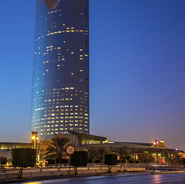 rascacielos iluminado parcialmente en un entorno cosmopolita, sede de nuestra oficina regional de Riyadh, en Arabia Saudita