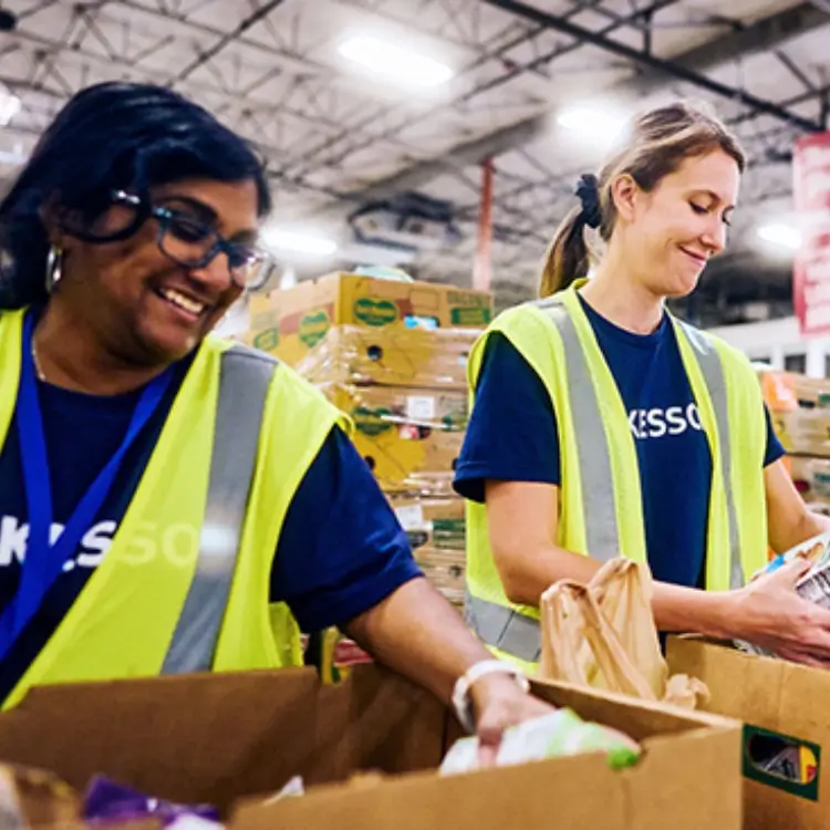 two McKesson employees packing boxes at a volunteer event