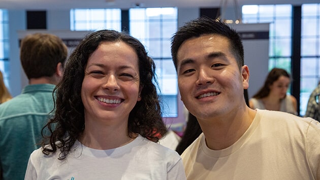 Male and female colleagues smiling next to one another