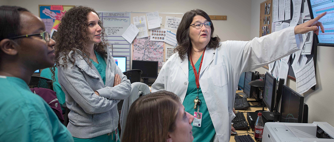 A doctor lecturing to a room of other medical professionals.