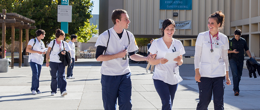 Three medical students walking along the hospital campus
