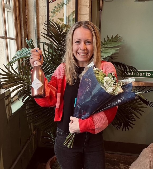 Colleague smiling with a gift of flowers