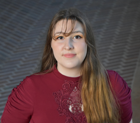 Sherry, long brown hair wearing a red sweater, smiling