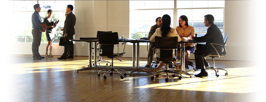 two small, separate groups of professionals discussing business matters