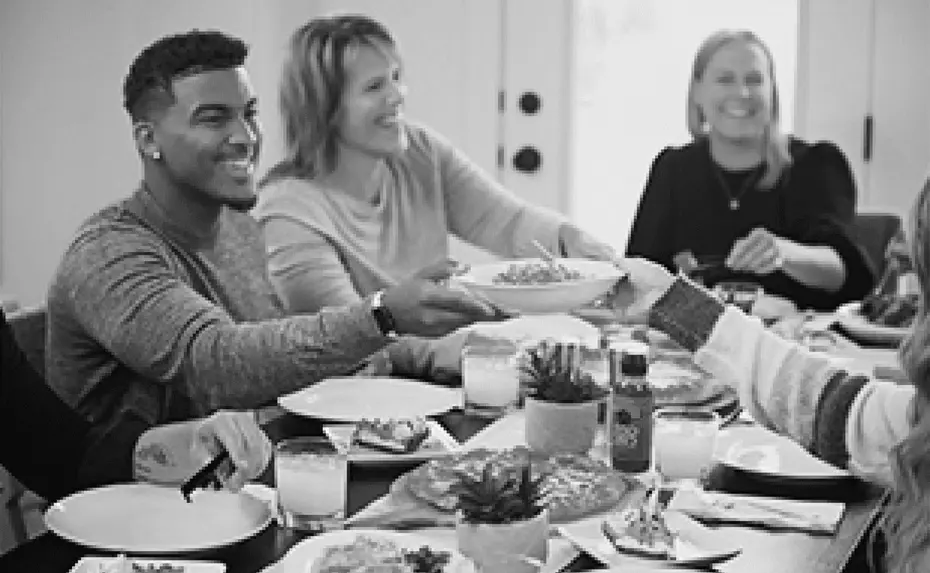 People sitting around a dinner table smiling