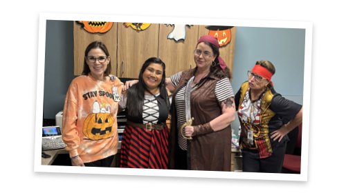 Beth poses in Halloween costumes with her colleagues