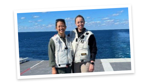 Susi stands and poses with a military colleague on the deck of a Navy sip