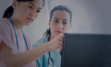 Two female nurses looking at monitor