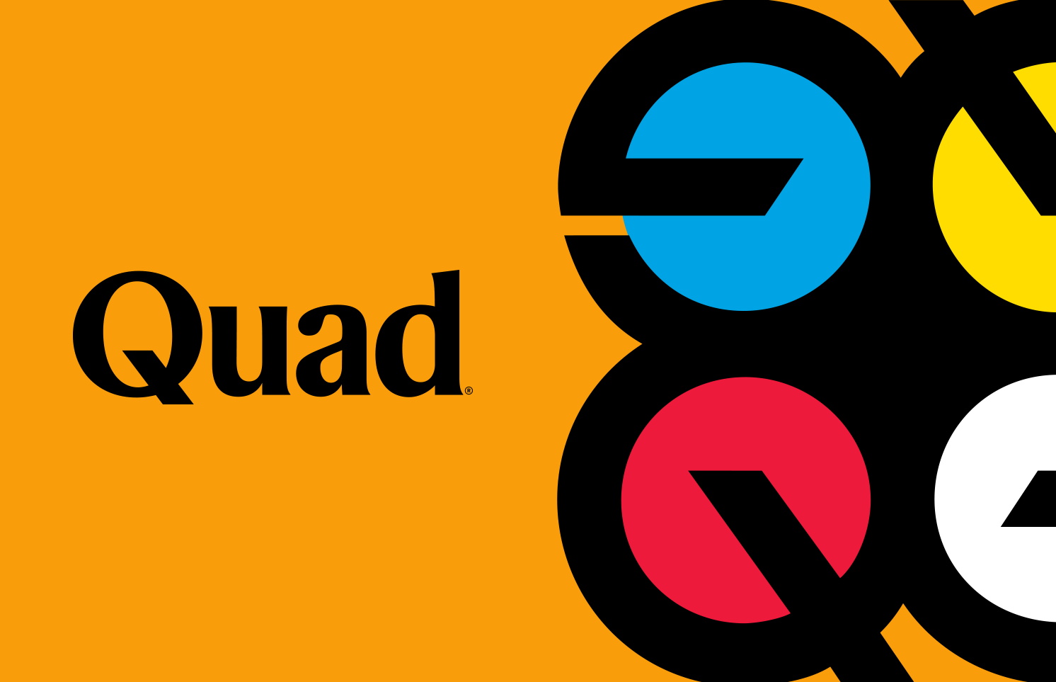 Quad employees conversing around a desk at headquarters