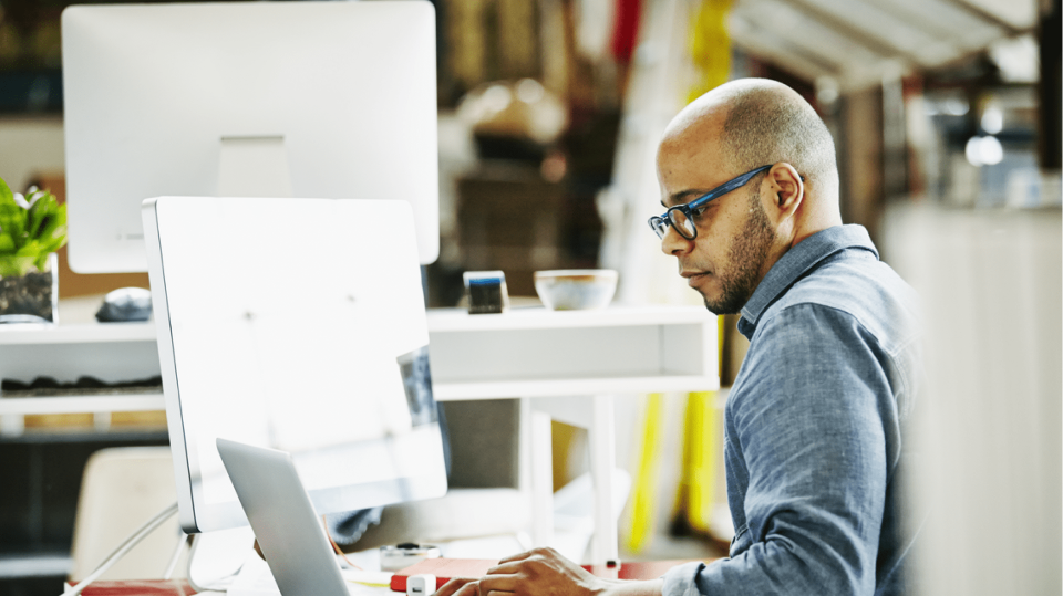 Quad information technology employee working at a desk