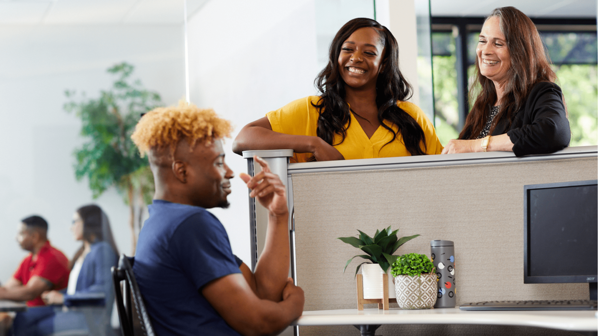 Quad employees conversing around a desk at headquarters