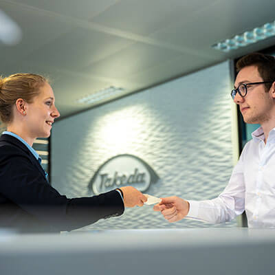 Woman handing paper to a Takeda employee