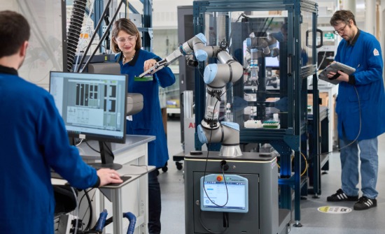 GSQ employees working with a cobot