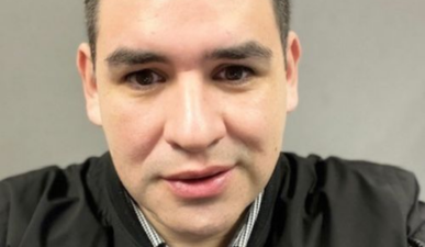 Man smiling looking into camera wearing black jacket