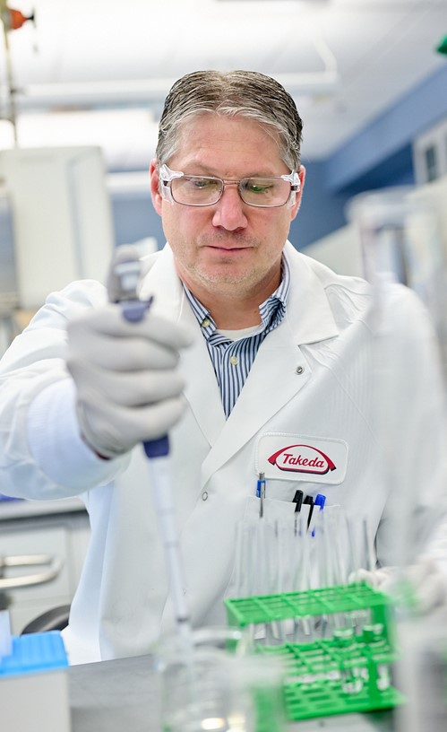 Male in labcoat handling equipment