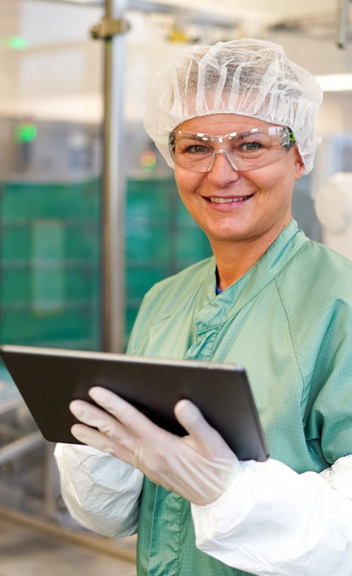 female in protective lab gear with tablet