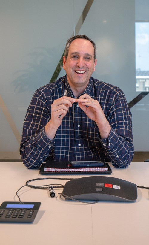 male at a desk smiling