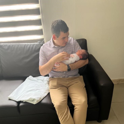 A man sitting on a couch holding a baby