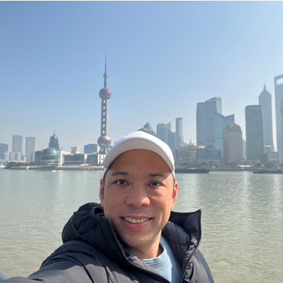 man smiling with a city skyline background