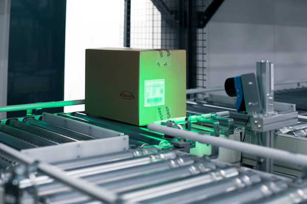 A box on an automated conveyor belt being scanned with technology