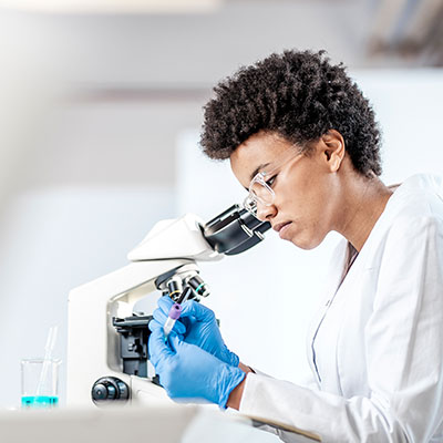Laboratory worker examining a microscope