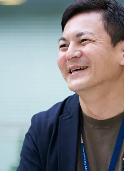 smiling asian male in business casual attire