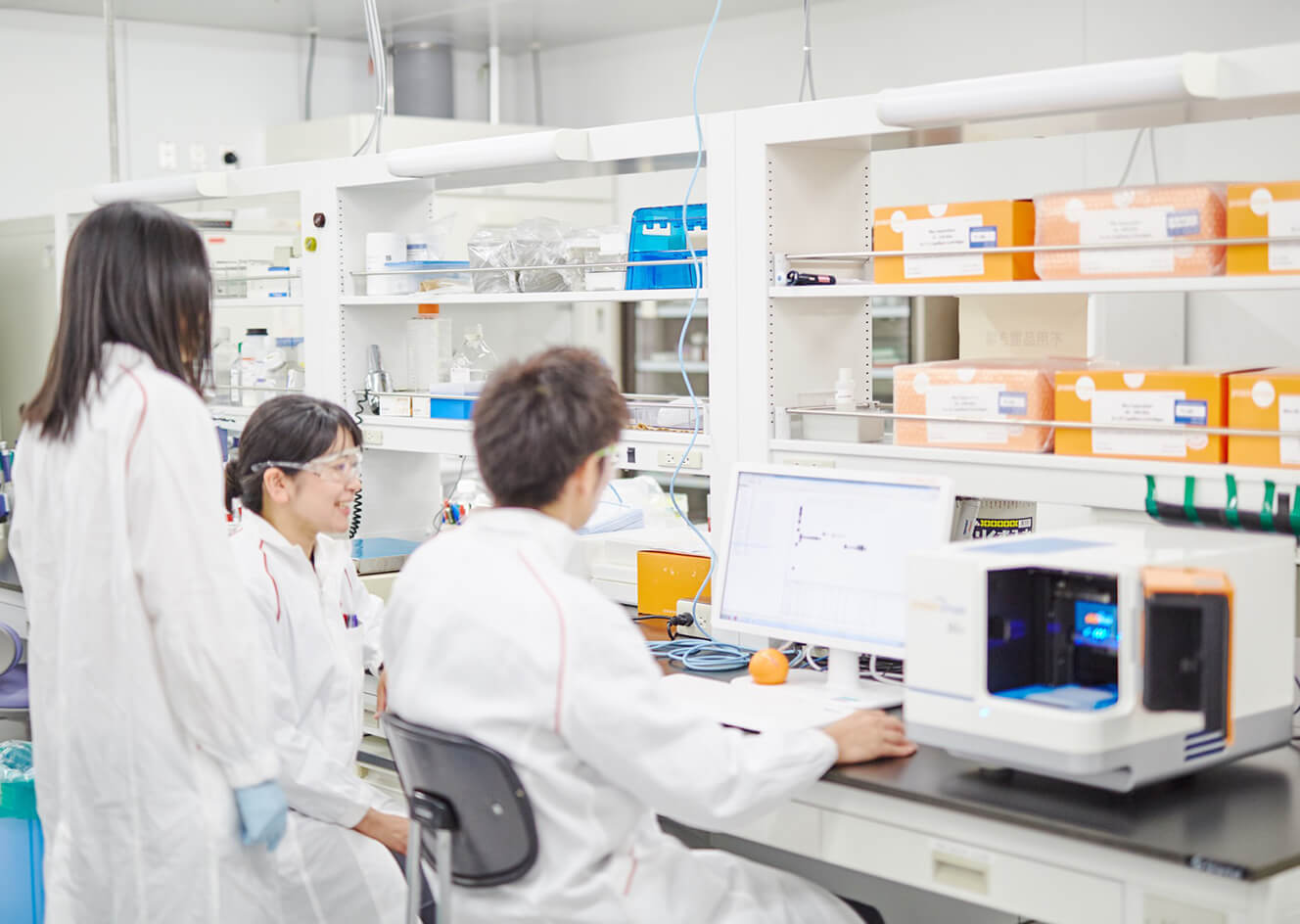 3 co-workers in a lab test with coat