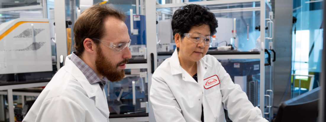 2 employees wearing lab coats and working in a laboratory