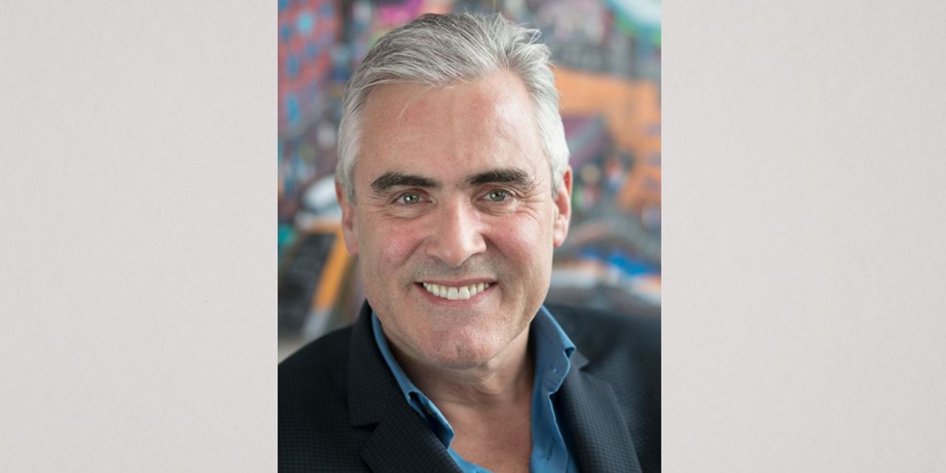 "A headshot of CIO Mike McNamara in a blue shirt against a blue background."