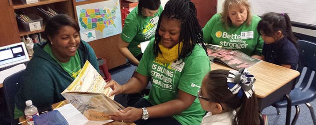 Four TD Ameritrade volunteers reading to elementary-school-aged children 