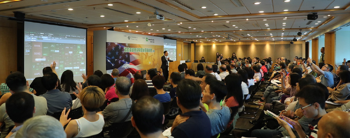 A large, excited crowd watching a presentation in a conference room in Hong Kong