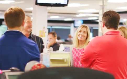 Four employees casually meeting in an open office, smiling 