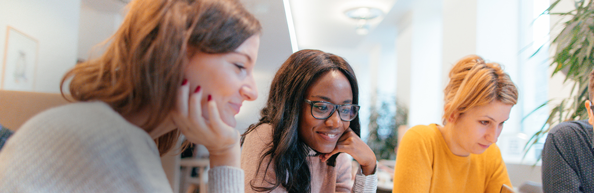 Three women working together in an open office