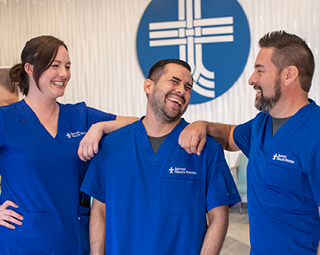 three employees in blue scrubs