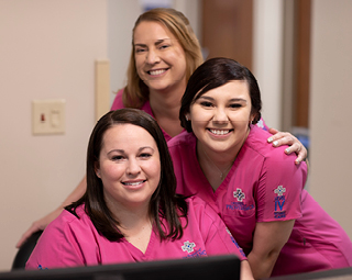 three female nurses in pink scrubs